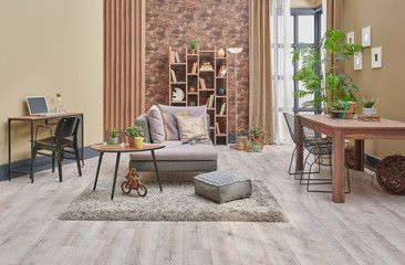Decorative brown interior room, wooden bookcase background, grey armchair, coffee table and parquet detail.