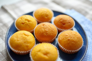 Pumpkin muffins on blue plate, selective focus. Homemade bakery, plant-based food