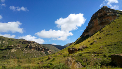 Fototapeta na wymiar Fluffy clouds over rock formations in the Golden Gate Highlands National Park, Clarens, Free State, South Africa