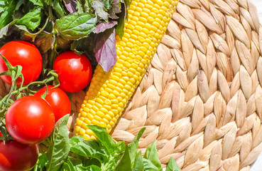Raw vegetables close up. Vegetables on table against background of white wall. view of fresh tomatoes, basil, eggplant, red pepper and corn. Healthy eating concept. Selective focus image.
