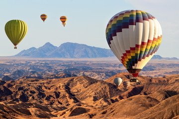 Colorful hot air  balloons flying over the moon valley mountain. Africa. Namibia.