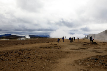 Fototapeta na wymiar Hverir / Iceland - August 30, 2017: Tourists walking at Hverir geothermal and sulfur area near Namafjall mountain, Myvatn Lake area, Iceland, Europe