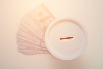 Selective focus of  money saving can in main focus with dollar on white background.