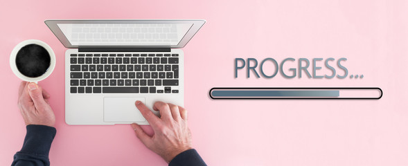 work progress concept, above view of person working on laptop computer and progress bar on pink...
