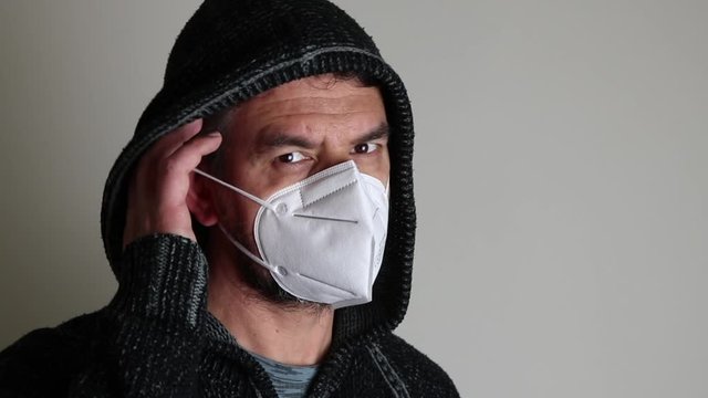 Uomo incappucciato con mascherina contro covid-19
