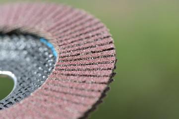 A new grinding wheel in front of a green, blurred background.