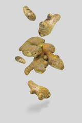 Fresh healthy ginger rhizomes isolated floating in the air, photomontage on white background....