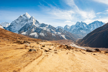 Fototapeta na wymiar Stunning valley with Dukh Koshi river leading to the Everest base camp with Ama Dablam peak. Trekking in Nepal Himalayas. EBC (Everest base camp trek) trail upper part from Lukla to EBC. Nepal.