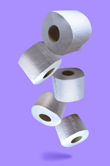 Five isolated toilet paper rolls on purple background, vertical. Fun, light, bubbly, comic.