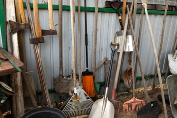 set of many different old rusty vintage gardening equipment near fence at shed storage in house...