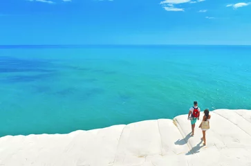 Fotobehang Scala dei Turchi, Sicilië white cliffs naturally made of smooth pug at Scala dei Turchi beach with group of young people with turquoise mediterranean sea and blue cloudy summer sky near Agrigento, Sicily, Italy