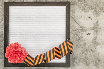 Message plate with empty place for text, red carnation, symbol of May 9th St. George’s ribbon and...