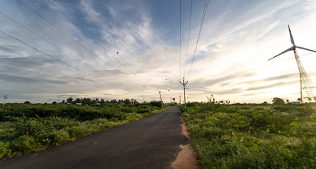 high voltage pillar power supply across a rural landscape during sunset