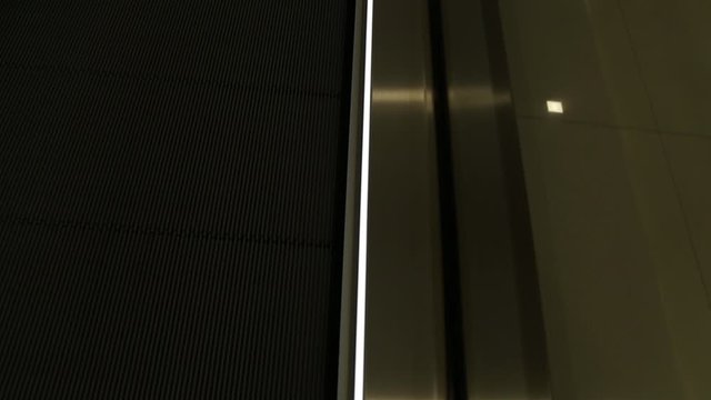 Part of travelator decorated with long strips of bright led lights on moving walkways to transport people horizontally at airports or a places where the walking distances are too long.
