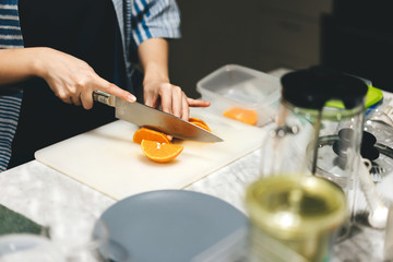 Obraz na płótnie Canvas Adult asian patisserie preparation cut orange for made a cake.