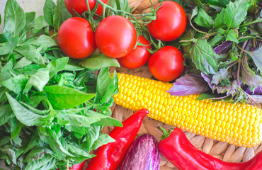 Raw vegetables close up. Top view of fresh tomatoes, basil, eggplant, red pepper and corn. Healthy eating concept, vegetable background. Selective focus image, flat lay. Copy space.