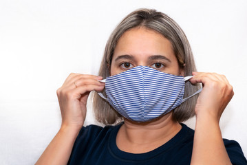 A young girl in a medical mask for protection from virus, dust, allergens. Protection from environmental factors