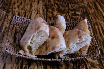 Pieces of pita bread in a basket on a table. Lavash is unleavened white bread in the form of a thin...