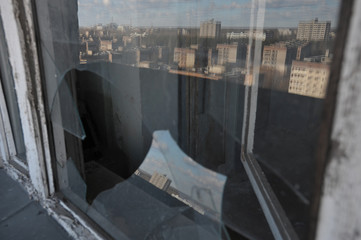 Reflection of ghost town in broken window in Chernobyl