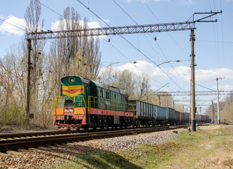 Green freight train travels by rail