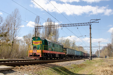 Green freight train travels by rail