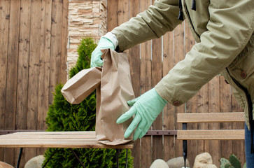 delivery of food in gloves in a paper takeaway bag. The concept of providing services. Place to...
