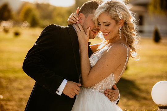 Beautiful wedding couple posing together in sunset