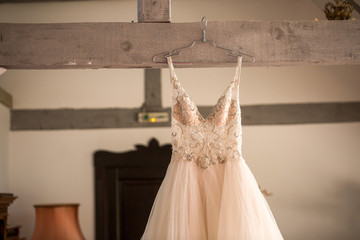 beautiful wedding dress hanged on wooden beam