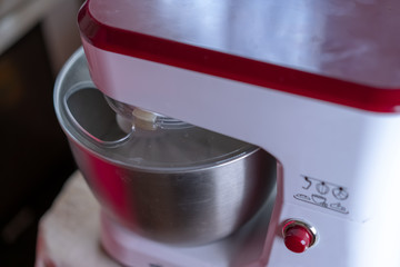 The mixer whips the dough to prepare it for baking.
