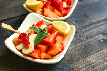 fruit salad with strawberries, yellow melon and banana with lemon. healthy dessert of seasonal fruits. 