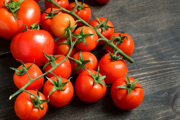 red tomatoes of different sizes and varieties on a wooden background. top view and copyspace. salad recipe ingredients for pasta. seasonal vegetables for healthy diet. selective focus