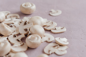 whole mushrooms and sliced ​​on a light pink background
