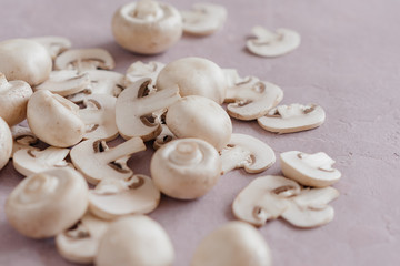 whole mushrooms and sliced ​​on a light pink background