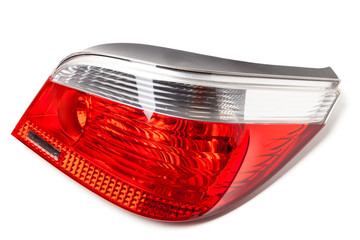 Stylish stoplight headlight made of white and red glass on a white isolated background in a photo studio. Spare part for the repair of the rear body in the workshop.