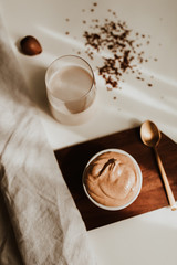 Flat lay of coffee cream and milk chocolate on a white background – minimalist breakfast concept in natural light