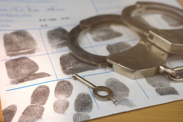 Crime and violence concept.Police Handcuffs on fingerprints crime page file - obrazy, fototapety, plakaty