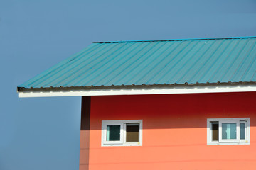 Fototapeta na wymiar Close up orange house with blue roof blue sky backgroun