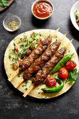 Adana Kebab with fresh vegetables on flatbread