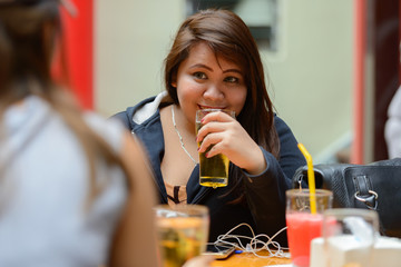 Happy young Asian women as friends hanging out and drinking beer outdoors