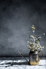 Willow bouquet with pussy willows, in metal vase, on grey background