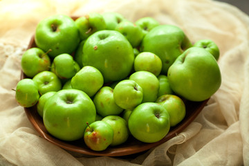 Fototapeta na wymiar Green organic healthy apples in bowl on wooden board. Healthy food