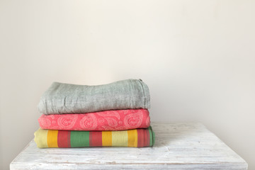 stack of slings for wrapping and carrying babies