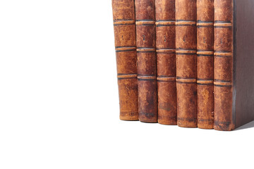 A stack of old books bound in brown leather, isolated on a white background. Space for text