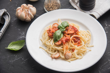 Spaghetti bolognese pasta with tomato sauce and minced meat on black table.