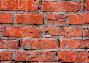 Seamless texture pattern background from old sprinkling red brick with protruding cement seams.