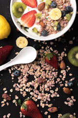 Granola. Granola with yogurt, on black wooden table