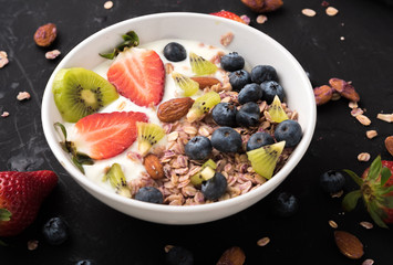 Granola. Granola with yogurt, on black wooden table