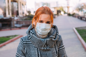 Street portrait of a young woman wearing protective medical mask during coronavirus pandemic - 342417025