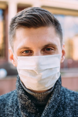 Street portrait of a man wearing protective medical mask during coronavirus pandemic - 342417225