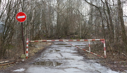 Fototapeta na wymiar The wet muddy road is blocked by a barrier